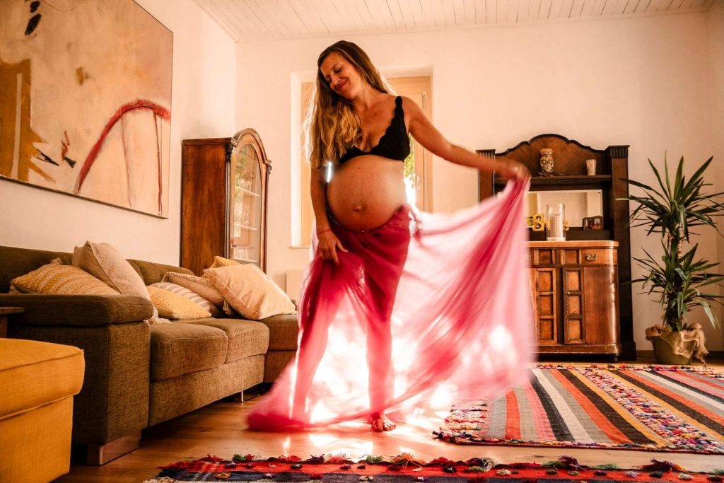 Schwangerenfotos tanzend voll Leichtigkeit im Morgenlicht zuhause