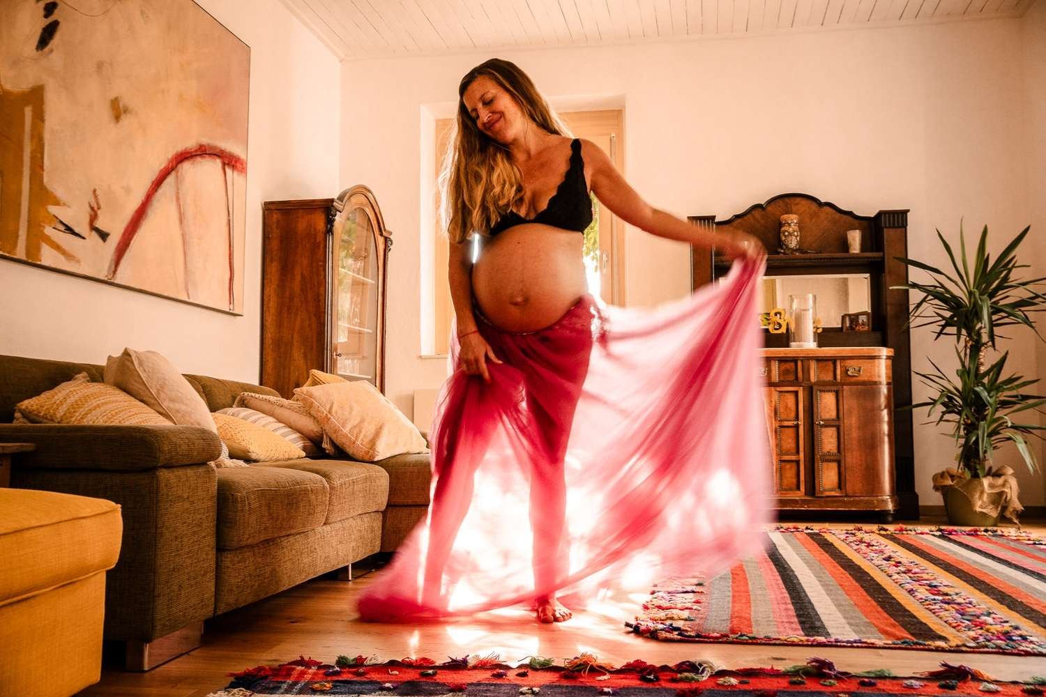 Schwangerenfotos tanzend voll Leichtigkeit im Morgenlicht zuhause