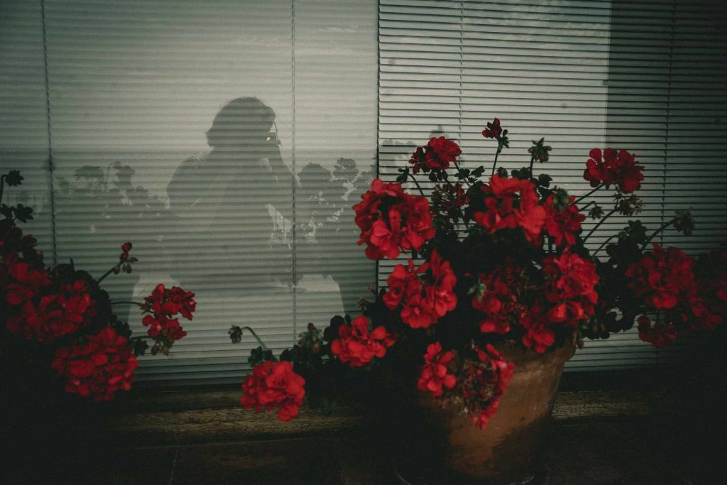 Intuit Retreat 4 Selbstportrait im Fenster mit Blumen in pink