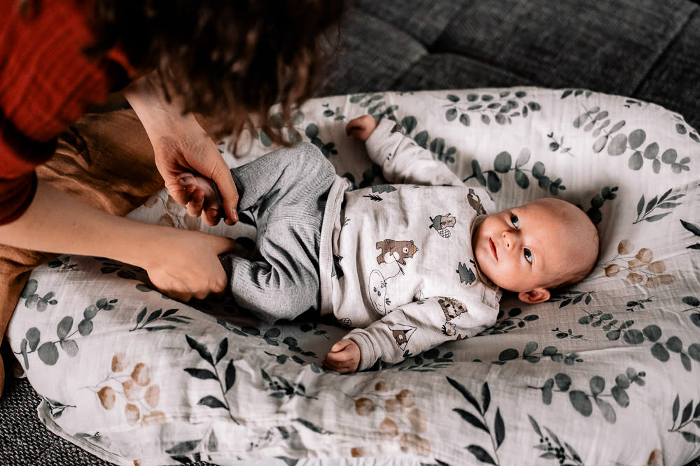 Fotobesuch im Wochenbett 14 Mutter hält Füsse vom Baby im Wochenbett