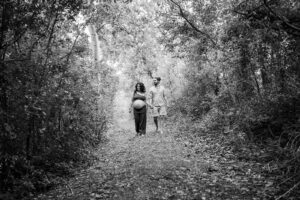 Babybauchfotos Paar spaziert durch Wald